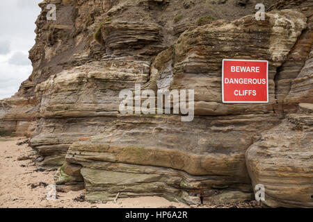 Warning sign about dangerous cliffs at Staithes, North Yorkshire, England,UK Stock Photo