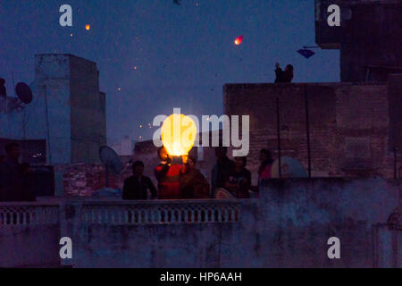 Jaipur, India - 14th Jan 2017 : Family standing on rooftop and releasing a sky lantern during the event of Makar Sankranti Stock Photo