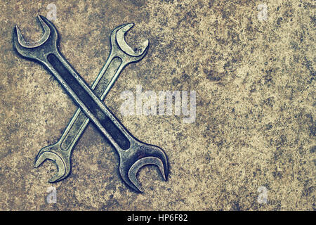 two crossed dirty wrenches on grunge concrete or cement background top view with place for text Stock Photo