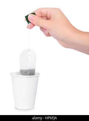 Woman hand with tea bag isolated on white background. Woman's hand holding tea bag. Making a cup of tea with a tea bag. White paper takeaway cup and h Stock Photo