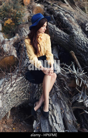 Beautiful woman dreaming outdoor. Autumn melancholy. Young brunette woman in elegant vintage blouse with bow and skirt with fashionable hat. Elegant f Stock Photo