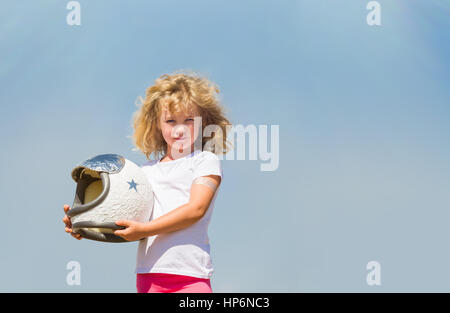 Portrait of blonde little girl in an astronaut costume dreaming of becoming a spacemen. Stock Photo