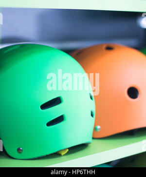 Inline and quad roller skates helmets head protection in retail skate shop display on sale. Stock Photo