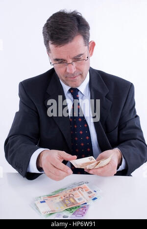 Model released , Geschaeftsmann zaehlt Geld - business man with money Stock Photo