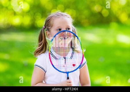 Active preschool girl playing badminton in outdoor court in summer. Kids play tennis. School sports for children. Racquet and shuttlecock sport for ch Stock Photo