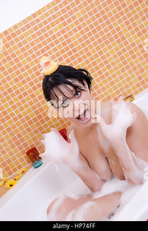 Model released, Junge Frau mit Badeente in der Badewanne - woman takes a bath Stock Photo