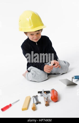 Model released, Junge, 4, mit Bauarbeiterhelm und Handwerkszeug - boy with building-site helmet and tools Stock Photo