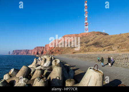 The red steep coast line of Helgoland, an German Island in the North Sea, coastal protection structure, concrete elements called Tetrapoden, steep coa Stock Photo