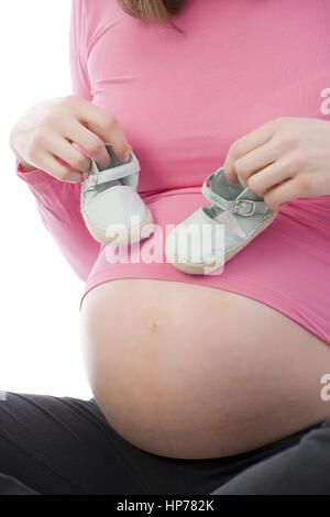 Model released, Schwangere Frau mit Babyschuhen - pregnant woman with baby shoes Stock Photo