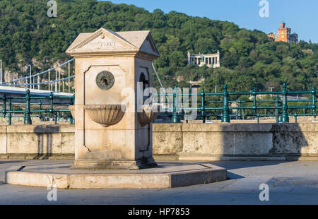 Urban stone column with water on the street Stock Photo