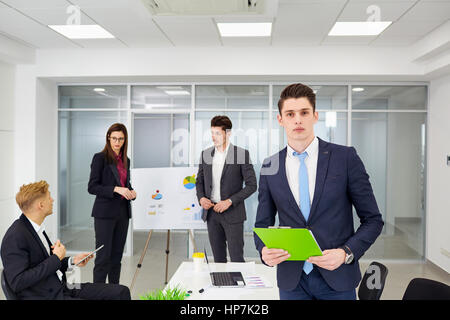 Young businessman working on background of colleagues in the off Stock Photo