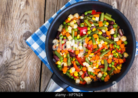 Mix of vegetables in frying pan on background of old boards. Studio Photo Stock Photo