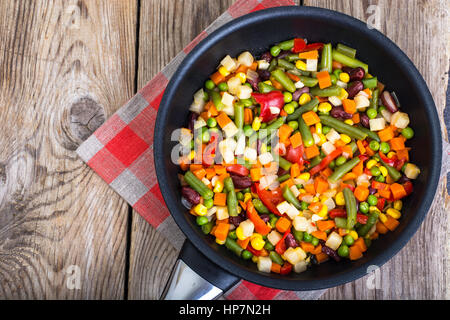 Mix of vegetables in frying pan on background of old boards. Studio Photo Stock Photo