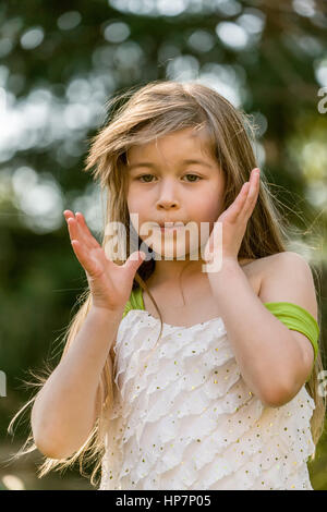 Portrait of seven year old girl acting whimsical and dreamy Stock Photo