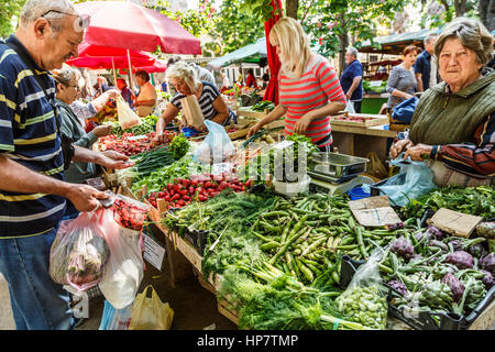 PULA, CROATIA - MAY 11, 2014: merchants sell fruits and vegetables in market stall on May 11, 2014 in Pula, Croatia Stock Photo