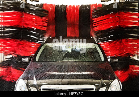 A black car is cleaned in a Gantry car wash. Stock Photo