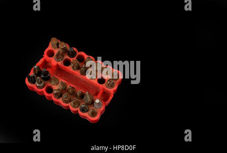 Used screwdriver bits in a red rubber organizer box Stock Photo