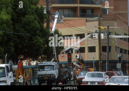 ELECTRICAL TECHNICIANS IN CHERRY PICKERS CARRY OUT MAINTENANCE ON HIGH VOLTAGE POWER LINES IN THE SYDNEY CBD. AUSTRALIA. Stock Photo