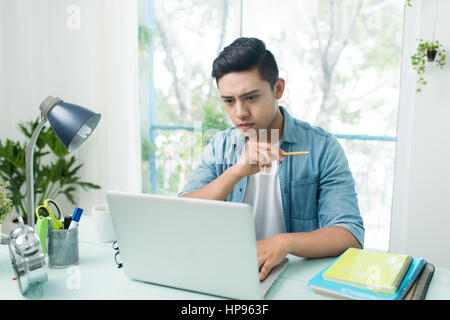 Student doing homework and preparing exam at home. Stock Photo