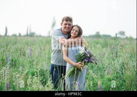 young couple embracing on summer meadow Stock Photo