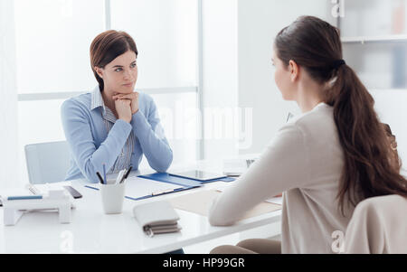 Business meeting in the office and job interview: a female executive is meeting the candidate and talking Stock Photo