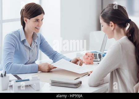 Business consultant and customer meeting in the office, the businesswoman is holding a contract and pointing Stock Photo