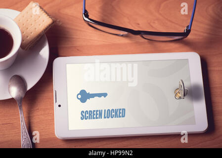 Tablet screen locked with the real lock with key Stock Photo