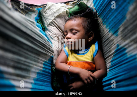 INDIA Odisha Orissa, Raygada, tribal village Bishnuguda, Dongria Kondh tribe, sleeping baby in cradle which is a Sari cloth / INDIEN Odisha Orissa, Raygada, Dorf Bishnuguda, Ureinwohner Dongria Kondh, schlafendes Baby in Tuch Stock Photo