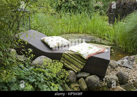 Liegestuhl am Gartenteich - deckchair at garden pond Stock Photo