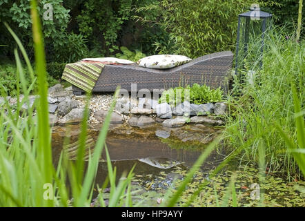 Liegestuhl am Gartenteich - deckchair at garden pond Stock Photo