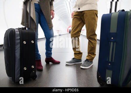 Unrecognizable couple in hallway of subway with trolley luggage. Stock Photo