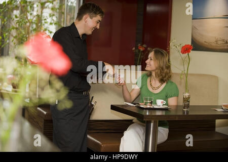 Model released , Kellner kassiert im Kaffeehaus - waiter cashed in cafe Stock Photo