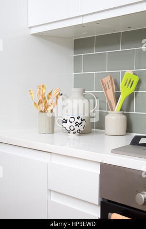 Kitchen utensils sit in pots beside the hob in a modern kitchen Stock Photo