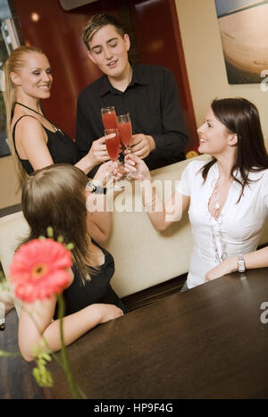 Model released , Vier junge Leute mit Erdbeerprosecco in einer Bar - young people with sparkling wine in a bar Stock Photo