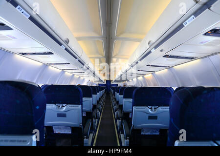 Airplane interior with blue seats and white panel Stock Photo