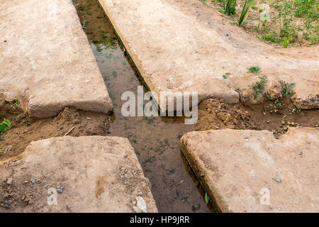 Merzouga, Morocco.  Irrigation Canal Carries Water to Farmers' Plots in the Merzouga Oasis.  Two Diversion Points are blocked, so that water flows to  Stock Photo