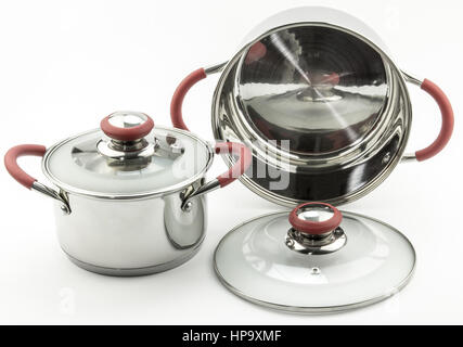 Set of classy stainless steel cooking pots isolated on white background - red handles and transparent glass lids Stock Photo