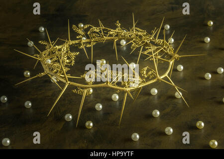 Gold crown of thorns on weathered brown background with pearls scattered - Conceptual of a king's suffering and the parable of the pearl of great pric Stock Photo