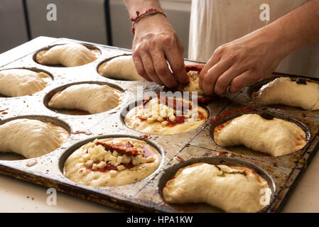Italian cuisine male chef hands in close-up making pizza and panzerotti on metal baking tray Stock Photo