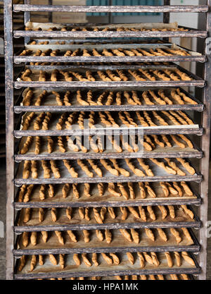 Full frame image of high professional oven with trays full of baked breadsticks in bakery. Bread production background concept Stock Photo