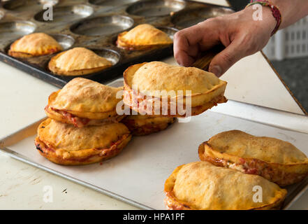 Close-up image of cook hand taking fresh cooked Italian panzerotti of baking tray Stock Photo