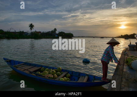 Coconut vendor at sunset on the Thu Bon River, Hoi An, Vietnam Stock Photo