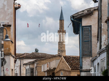 A Turkish Cypriot flag next to a tower of the mosque near the border of the wall that divide the city of Nicosia, Cyprus. Nicosia was divided into the southern Greek Cypriot and the northern Turkish Cypriot parts in 1963, following the intercommunal violence that broke out in the city. Today, the northern part of the city is the capital of Northern Cyprus, a de facto state that is considered to be occupied Cypriot territory by the international community. ©Simone Padovani / Awakening Stock Photo