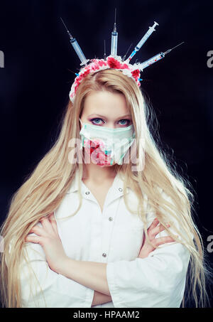 Halloween costume of a crazy nurse with crown made of syringes and a syringe in the hand Stock Photo