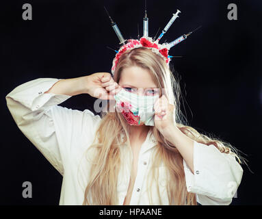 Halloween costume of a crazy nurse with crown made of syringes and a syringe in the hand Stock Photo