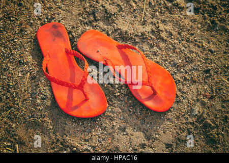 Pair of flip flops on the beach in the sunny afternoon. Stock Photo
