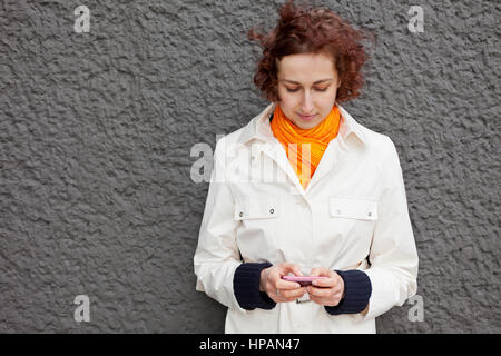 Young attractive woman using her smartphone outdoors Stock Photo