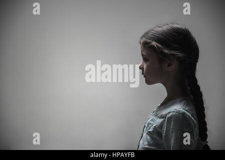 Think about you. Little girl with turned-up nose looking straight while standing in semi position Stock Photo