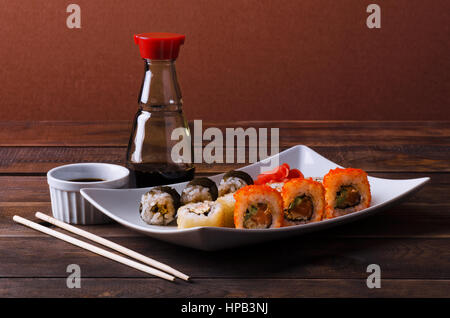 Sushi roll on a plate with soy sauce and chopsticks Stock Photo