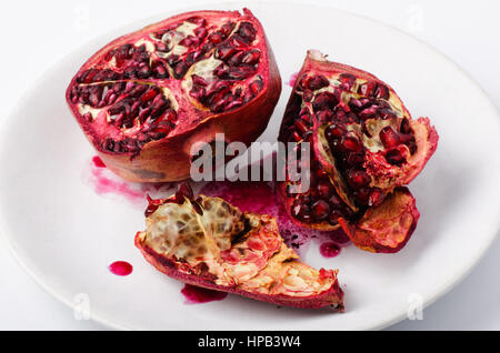 Fresh ripe pomegranate on a plate on a white background Stock Photo